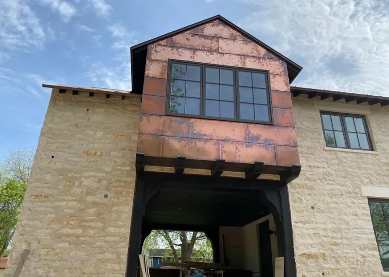 Copper metal panel facade on a stone building for Skylight Installation in Magnolia