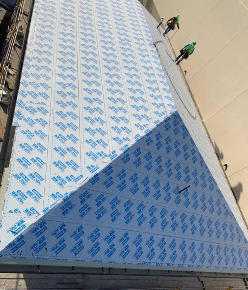 Professional roofers installing underlayment on a metal roof in Magnolia